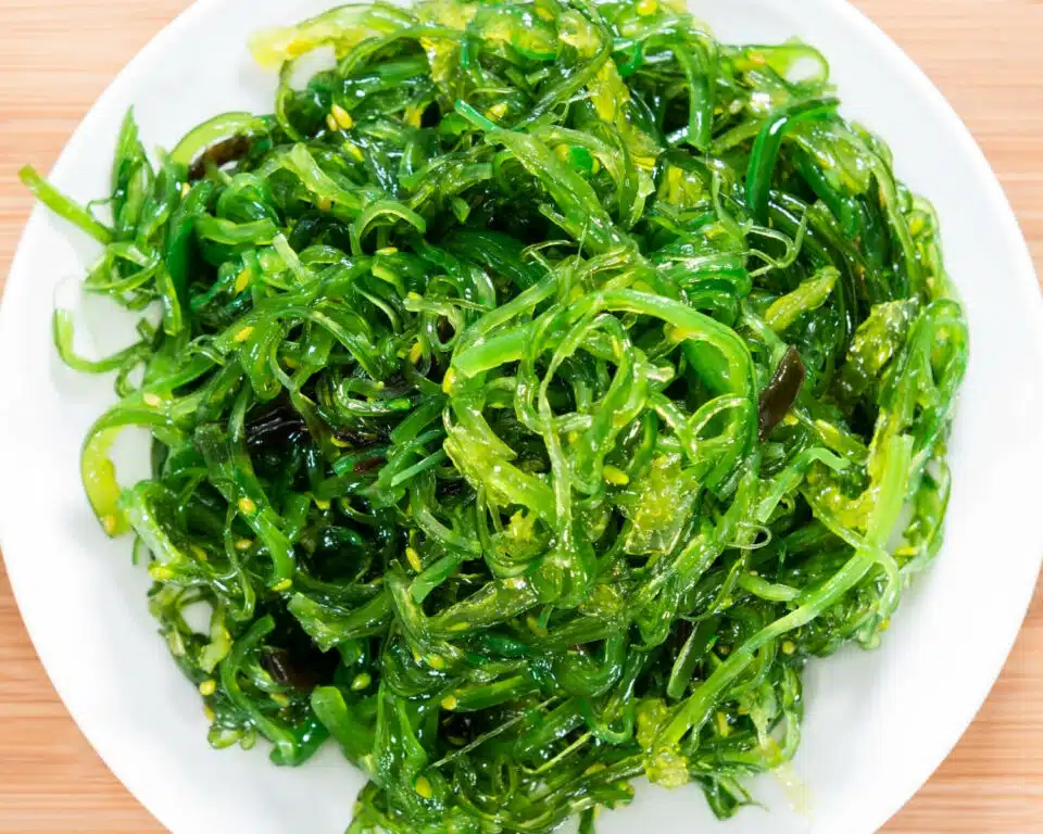 Looking down on a plate of bright green kelp noodles.